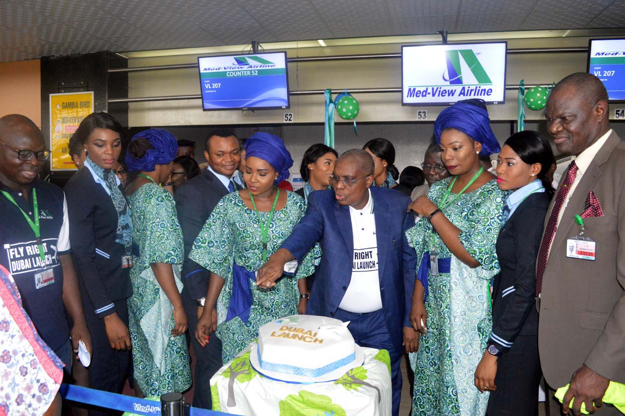 Alhaji Muneer Bankole, MD/CEO, Med-View Airline with other passengers on board cutting the cake to celebrate Med-View Airline Lagos-Abuja-Dubai inaugural flight.