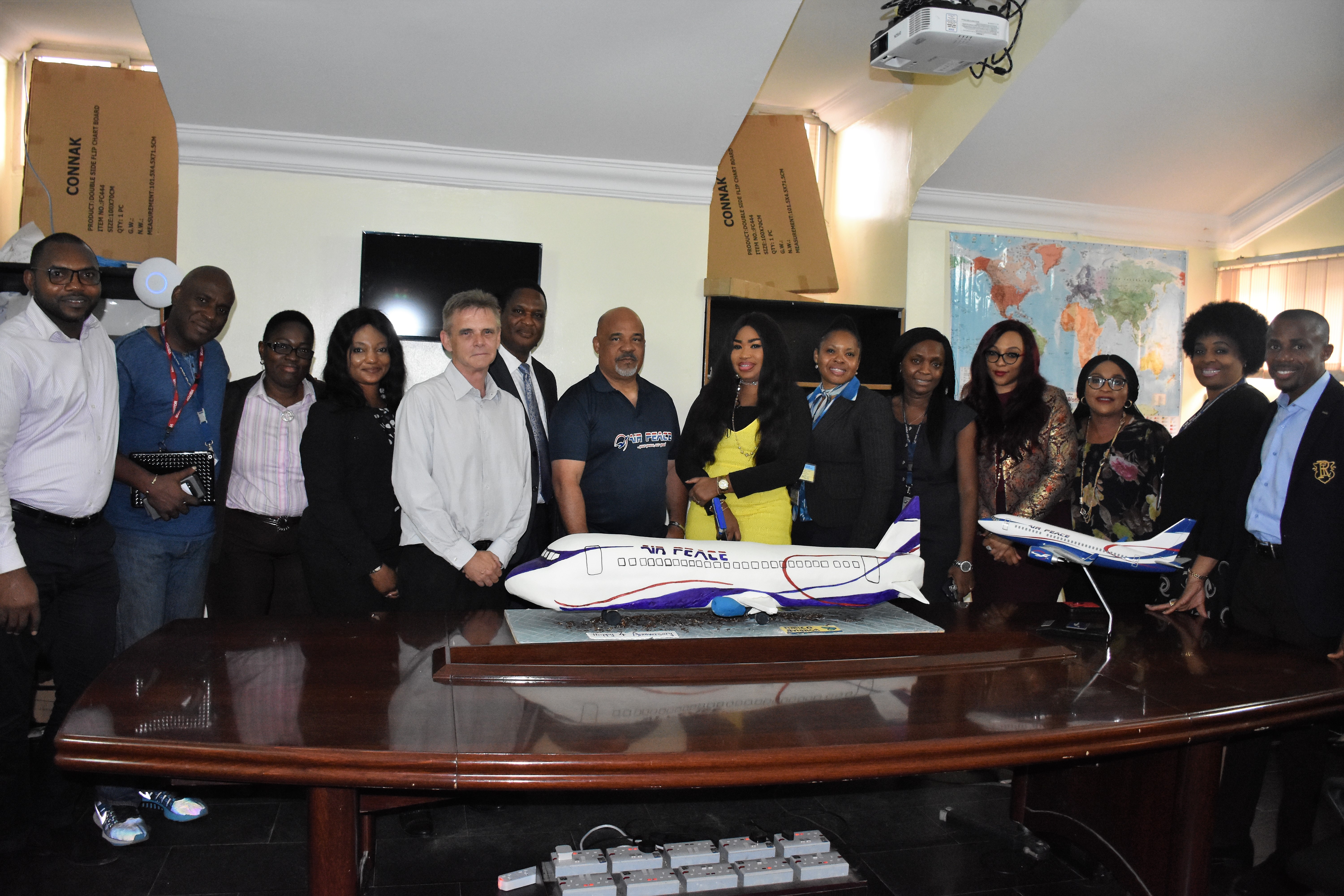 Air Peace Chief Operating Officer, Mrs. Oluwatoyin Olajide (8th left), Chief Pilot, Capt. Victor Egonu (7th left), Safety Manager, Capt. Godfrey Ogbogu (6th left), Technical Director, Engineering, Bryan Rigby (5th left), Assistant Human Resources Manager, Mrs. Margaret Osa (3rd left), Head of Training, Capt. Ndubuisi Ekwempu (2nd left), Deputy Human Resources Manager, Mr. Ume Ume (left), Human Resources Manager, Mrs. Olubunmi Akano (5th right), Business Development Manager, Tracy Osakwe (4th right), Assistant Customer Relations Manager, Mrs. Patricia Ebilah (3rd right), Training Coordinator, Mrs. Eira Gafar (2nd right), Corporate Communications Manager, Mr. Chris Iwarah (right), Head of Commercial and Business Development, Nigerian Aviation Handling Company (NAHCO), Chioma Offor (6th right) and Client Relationship Manager (Domestic), NAHCO, Temitope Ade-Dosunmu during a visit by NAHCO team to present a congratulatory message and anniversary cake to Air Peace at its Corporate Headquarters in Lagos on Wednesday