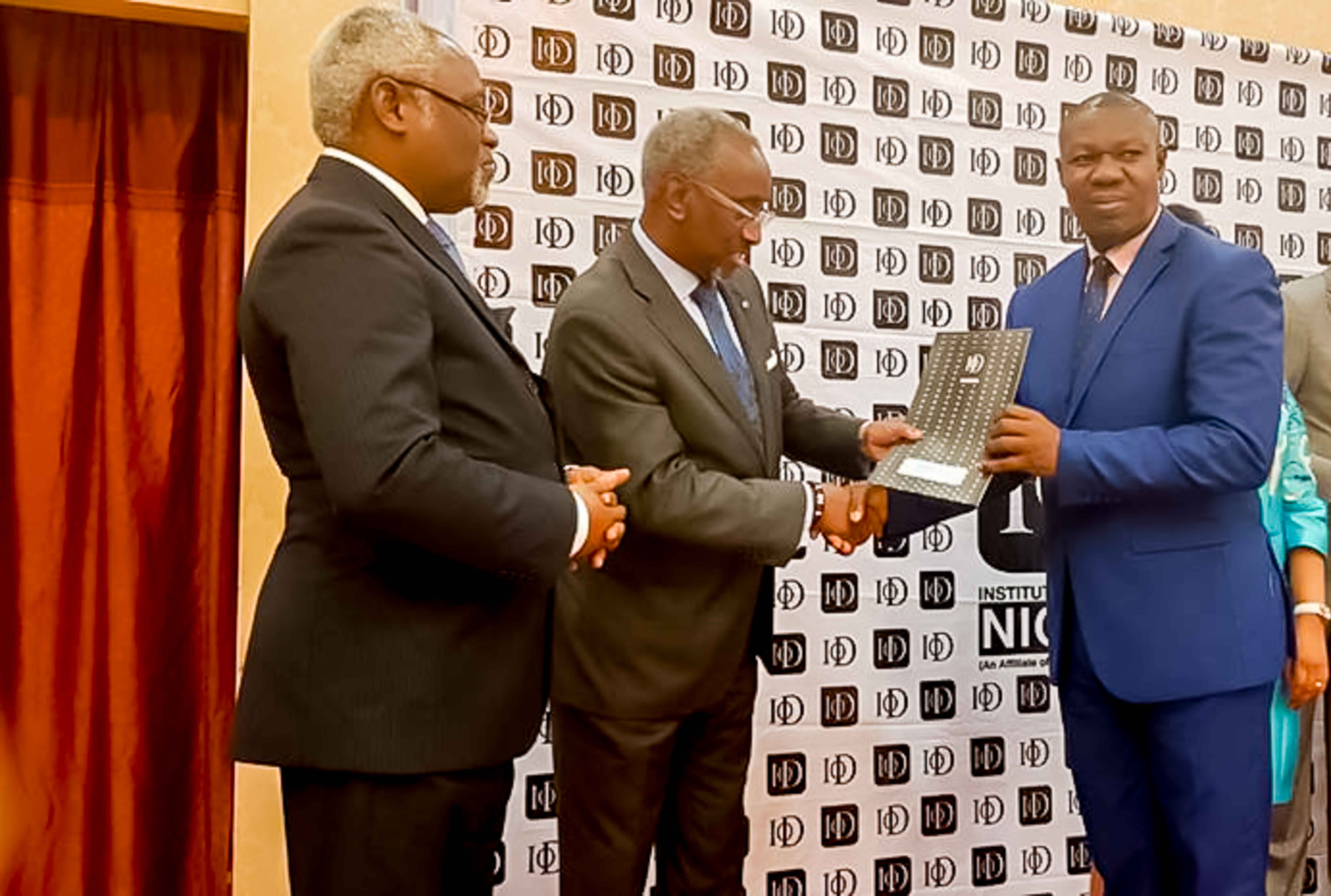 Basil Agboarumi, MD/CEO, SAHCOL, receiving the IoD certificate from Chief Chris Okunowo while Mr Samuel Akeju looks on.