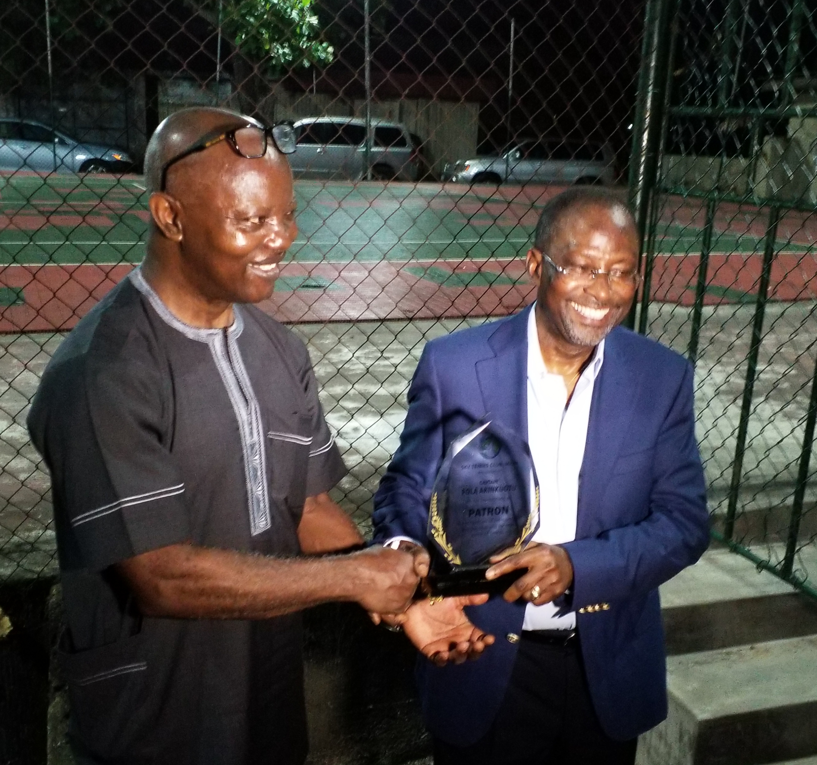 Chairman, Sky Tennis Club, Capt. Muyiwa Bajomo (left) presenting a plaque to Capt. Fola Akinkuotu at his investiture as patron of the club.