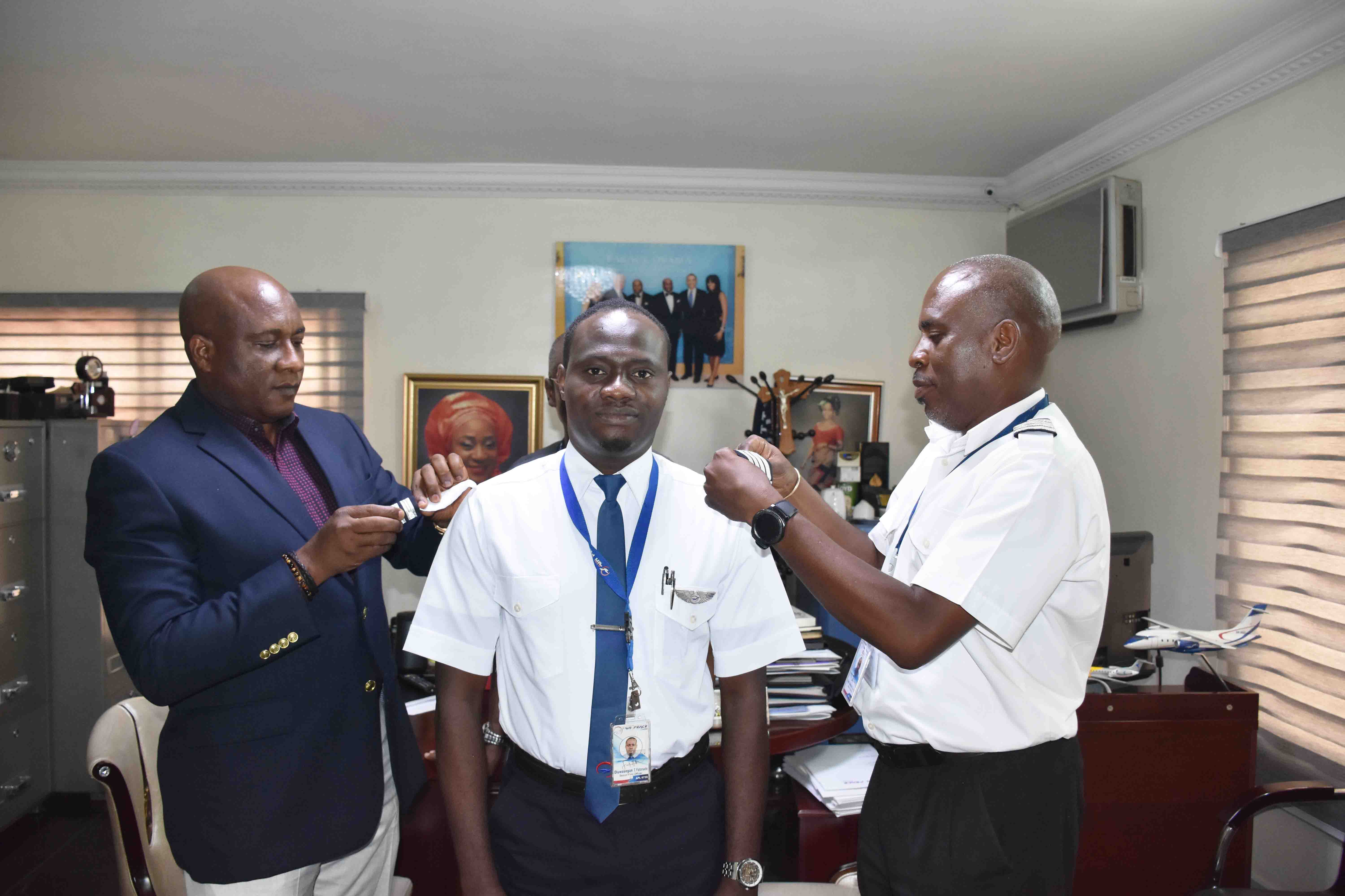 Air Peace Chairman/CEO, Mr. Allen Onyema (left) and Head of Training, Capt. Ndubisi Ekwempu (right) decorating Mr. Oluwasegun Fatonade with his new rank of captain at the airline’s corporate headquarters in Lagos recently.