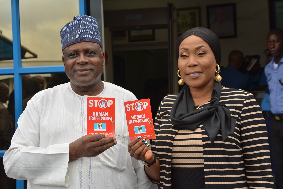 Usman and Okah-Donli displaying a flier to sensitize the public against human trafficking